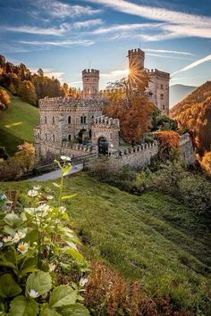 an old castle sitting on top of a lush green hillside