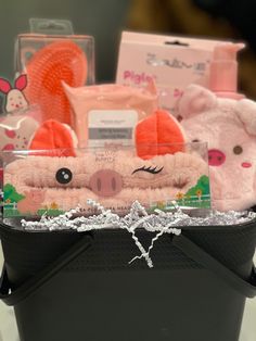 a basket filled with pink stuffed animals and other items on top of a white table