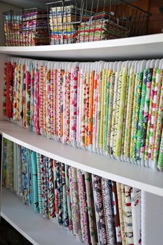 the shelves are filled with many different fabrics