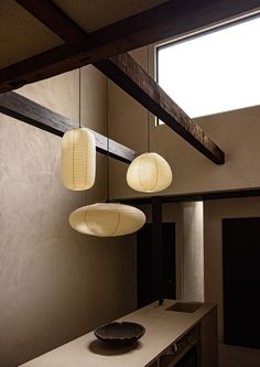 three lamps hanging from the ceiling above a counter