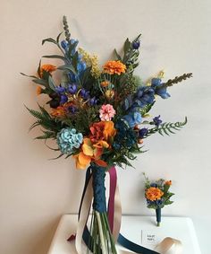 a bouquet of flowers sitting on top of a white table next to a pair of scissors