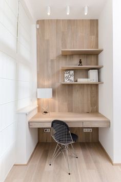 a chair sitting in front of a desk on top of a hard wood floor next to a book shelf