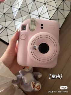 a person holding a pink camera in their hand