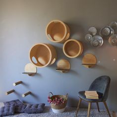 several wooden bowls are hanging on the wall next to a chair and ottoman in a living room