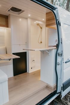 the interior of a camper van with its door open and shelves on either side