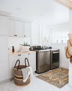 a laundry room with a washer and dryer next to a basket on the floor