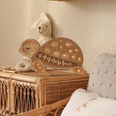 a teddy bear sitting on top of a basket next to a stuffed animal and lights