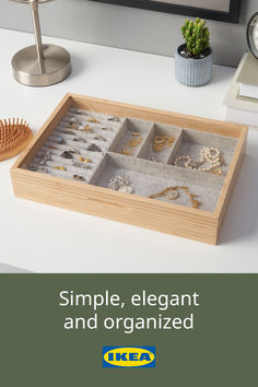 a wooden tray with jewelry on top of a desk