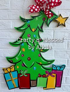 a wooden christmas tree with presents on it and the words crafty n blissed by alcia