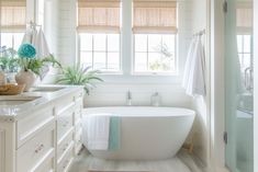 a bathroom with a tub, sink and window in it's centerpieces