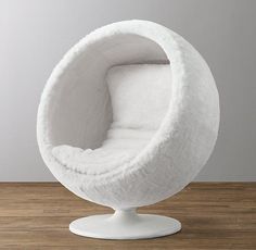 a white ball chair sitting on top of a wooden floor