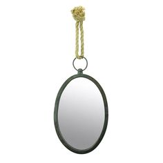 an oval mirror hanging on a rope with a knot around the edge and a round mirror in the middle