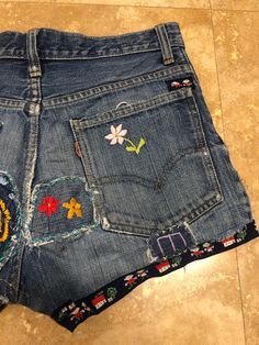 Embroidered Dark Wash Cotton Bottoms, Dark Wash Embroidered Cotton Bottoms, 70s Jean Shorts, Retro Embroidered Bottoms For Spring, Embroidered Cotton Jean Shorts, Embroidered Cotton Short Jeans, Embroidered Cotton Short Length Jeans, Embroidered Cotton Cutoff Bottoms, Vintage Patchwork Bottoms