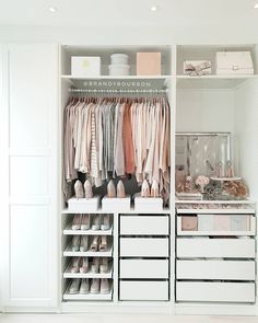 an organized closet with white drawers and clothes hanging on the wall, along with shoes