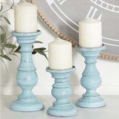 three candles sitting on top of a table next to a clock