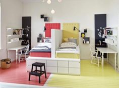 a room with two beds, desks and shelves on the wall next to each other