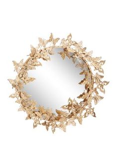 a round mirror with gold leaves on it