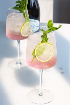 two glasses filled with pink lemonade and lime