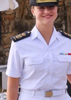 a woman in uniform is smiling for the camera