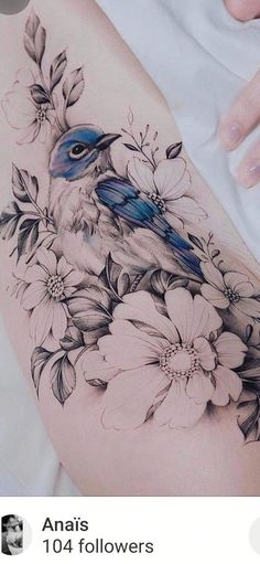 a blue bird sitting on top of a white flower covered arm with flowers around it