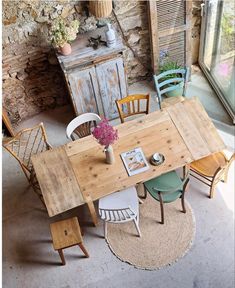 an overhead view of a table and chairs in a room with stone walls, potted plant on the floor