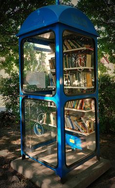 a blue public phone booth with books in it