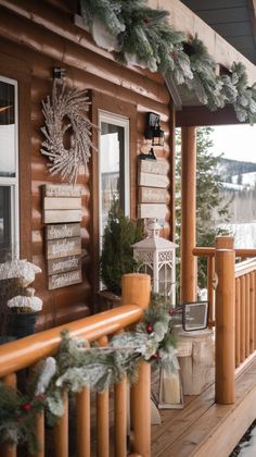 a porch decorated for christmas with pine cones and wreaths on the railing, snowflakes and lanterns