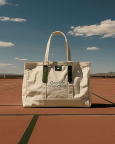 a white bag sitting on top of an airport tarmac under a cloudy blue sky