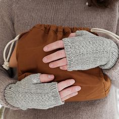 the woman is wearing gloves and holding her purse