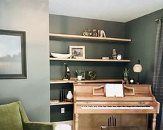 a living room filled with furniture and a piano in front of a wall mounted shelf