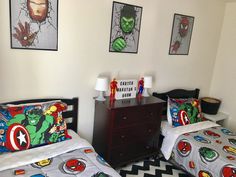 two beds in a room with pictures on the wall