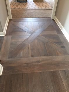 an open door leading to a bathroom with wood floors and tile on the flooring