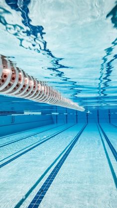 an empty swimming pool with no people or swimmers in the water and shadows on the floor