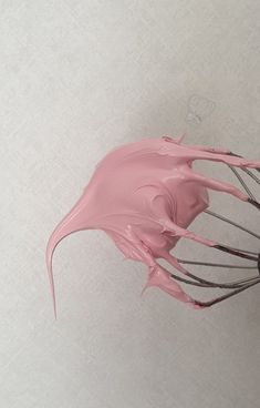 a whisk being used to make pink icing