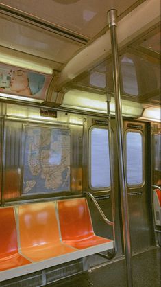 the inside of a subway car with orange seats