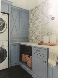 a washer and dryer in a blue laundry room with patterned wall paper on the walls