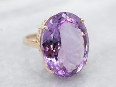 This ring is truly gorgeous! A large and beautiful saturated purple amethyst sits in the center, with an amazing cut and vibrant color that flickers with bright pops of violet! The stone is expertly cut to really display the stone’s color and sparkle. The simple mounting and prongs are all this stone needs to frame it to perfection!Metal: 14K Yellow GoldGem: Amethyst 18.97 CaratsGem Measurements: 10.3 x 15.5 mm, OvalRing Size: 7Marks: “14K” Stamped on the inside band Platinum Halo Ring, Rose Gold Halo Ring, Yellow Gold Amethyst Ring, Opal Statement Ring, Amethyst Cocktail Ring, Gold Amethyst Ring, Rose Gold Halo, Right Hand Ring, Pink Tourmaline Ring