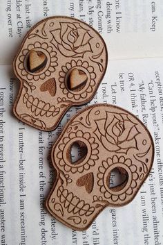 two wooden sugar skulls sitting on top of an open book