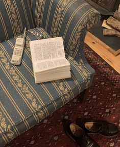 a pair of shoes sitting on top of a couch next to a book