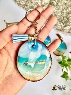 a hand holding a keychain that has an image of the ocean on it