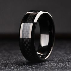 a black and white wedding ring with carbon fiber inlay