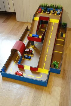 a toy train set with cars and ramps on the floor