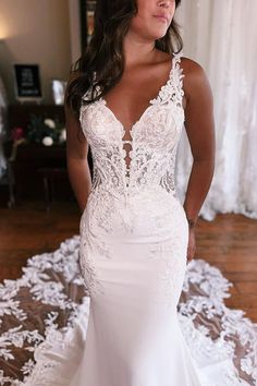 a woman in a white wedding dress posing for the camera