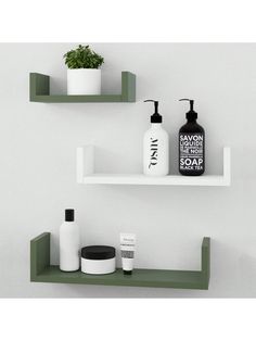 two shelves with soaps, lotion bottles and a potted plant on them