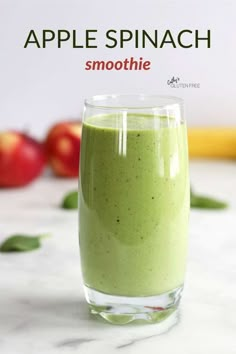 an apple spinach smoothie in a glass on a counter