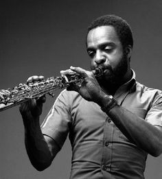 a black and white photo of a man playing the flute