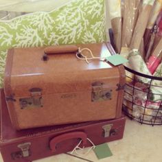 two suitcases are stacked on top of each other in front of a green pillow