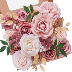 a bouquet of pink and white flowers in a cardboard box with gold foil leaves on it