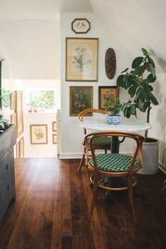 a dining room with wooden floors and pictures on the wall