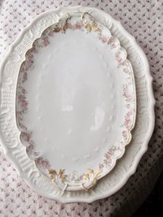 three white plates sitting on top of each other in front of a tablecloth covered table